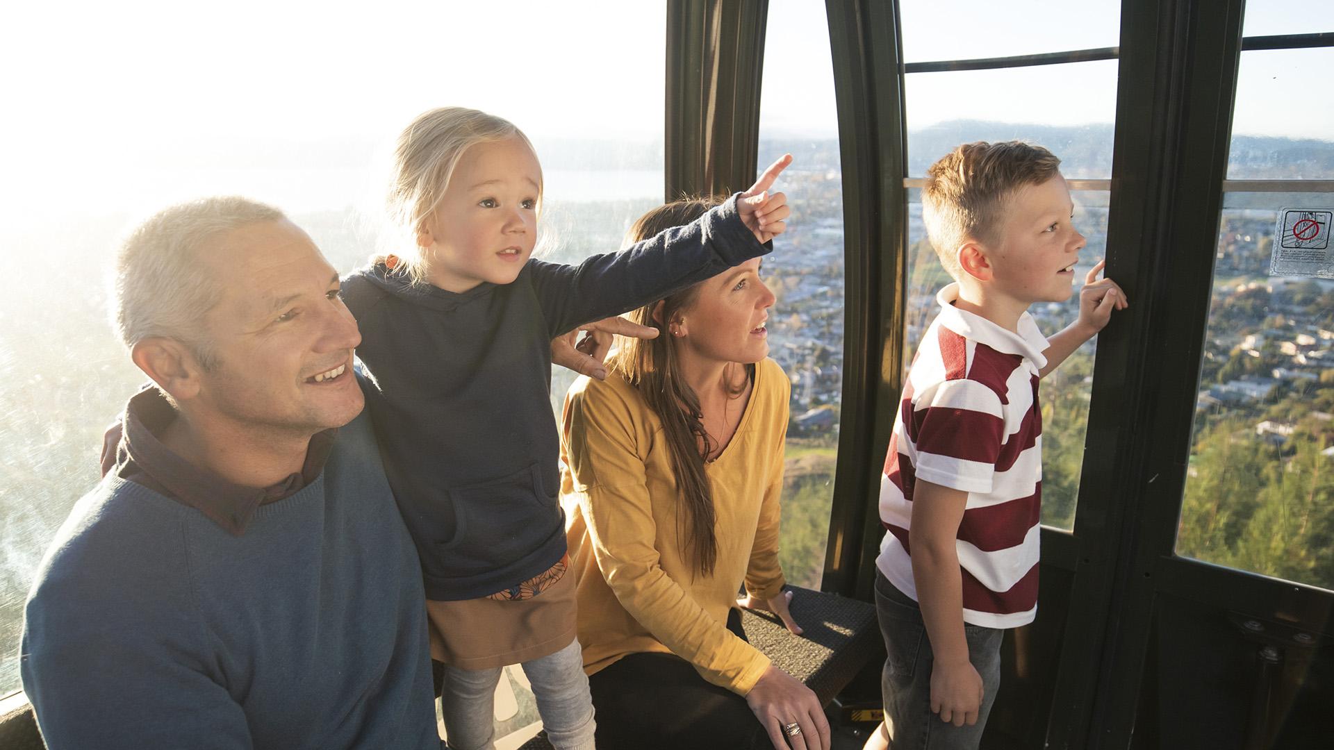 Image of family inside the Gondola cabin with little girl pointing at the views