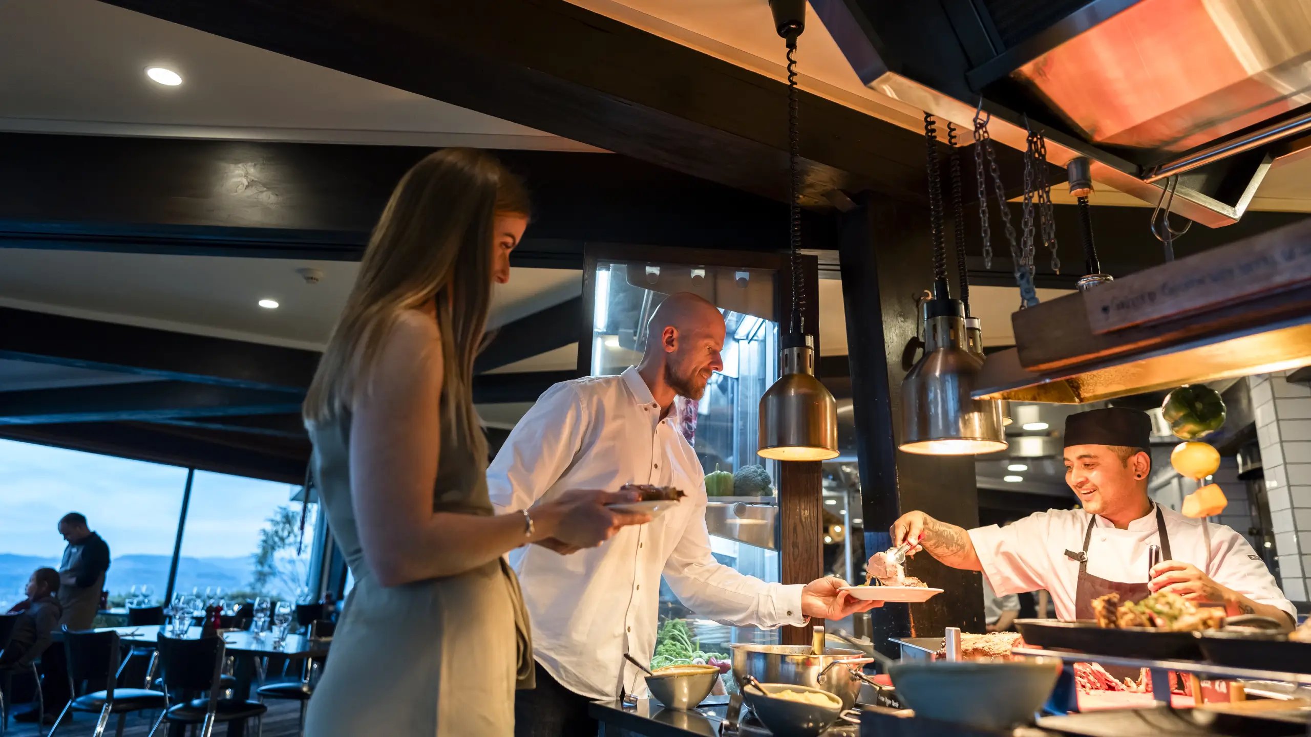 Guest selecting hot buffet dishes during lunch service at Stratosfare Restaurant, Skyline Rotorua.