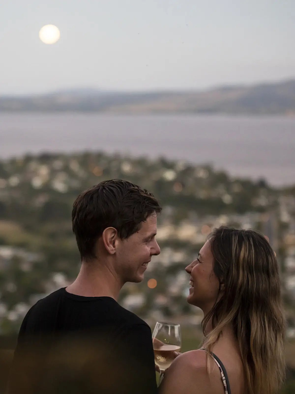 Couple enjoying sunset views over Rotorua and Lake Rotorua from Skyline