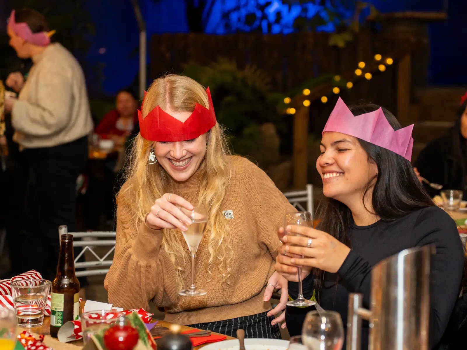 Guests wearing Christmas hats enjoying drinks and laughing at a festive function at Skyline Rotorua