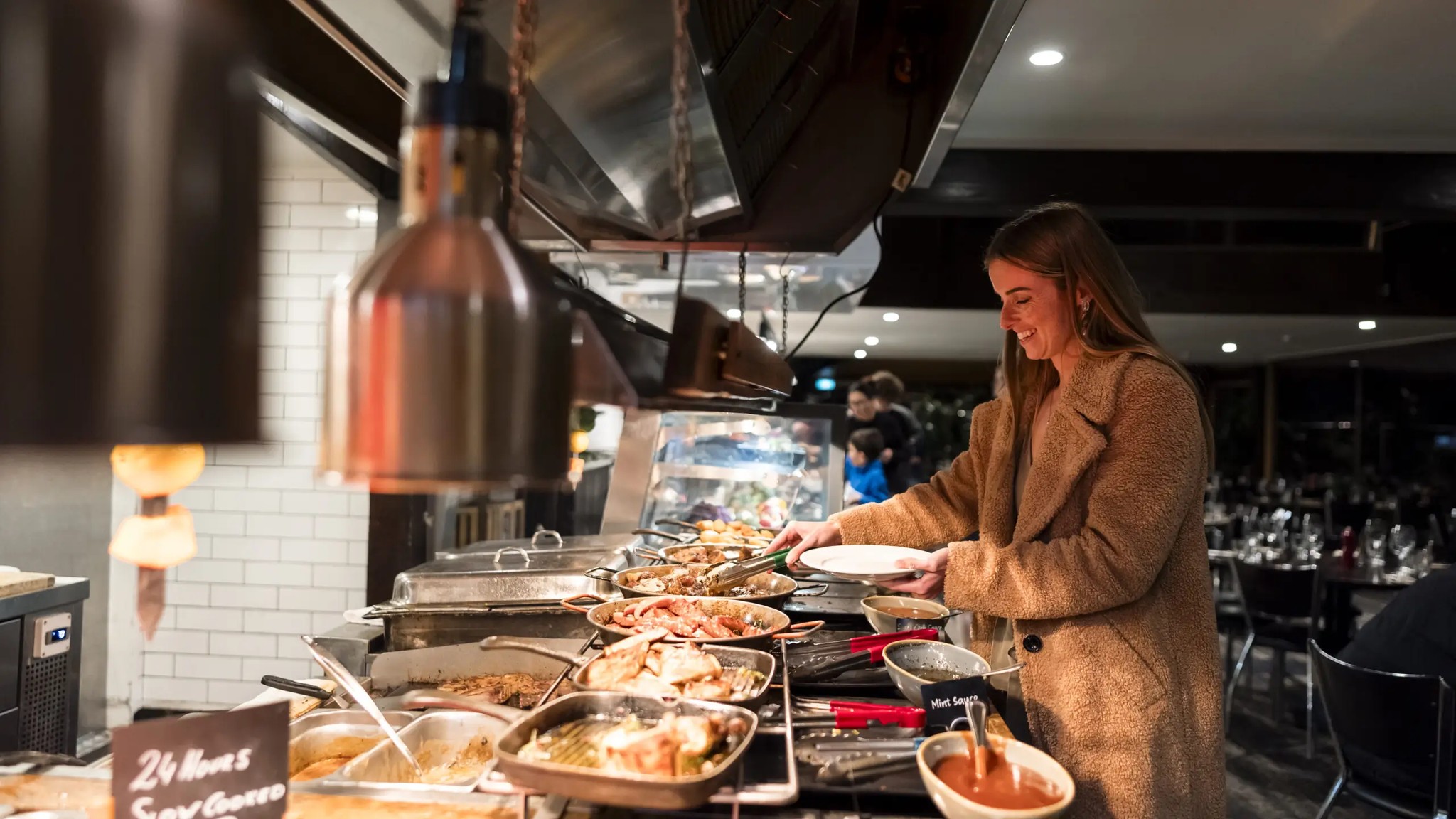 Guest enjoying buffet dining at Stratosfare Restaurant Rotorua during a cosy winter evening.