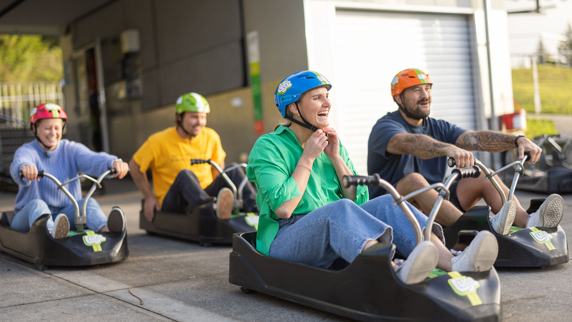 Image of lady sitting in luge kart putting on helmet