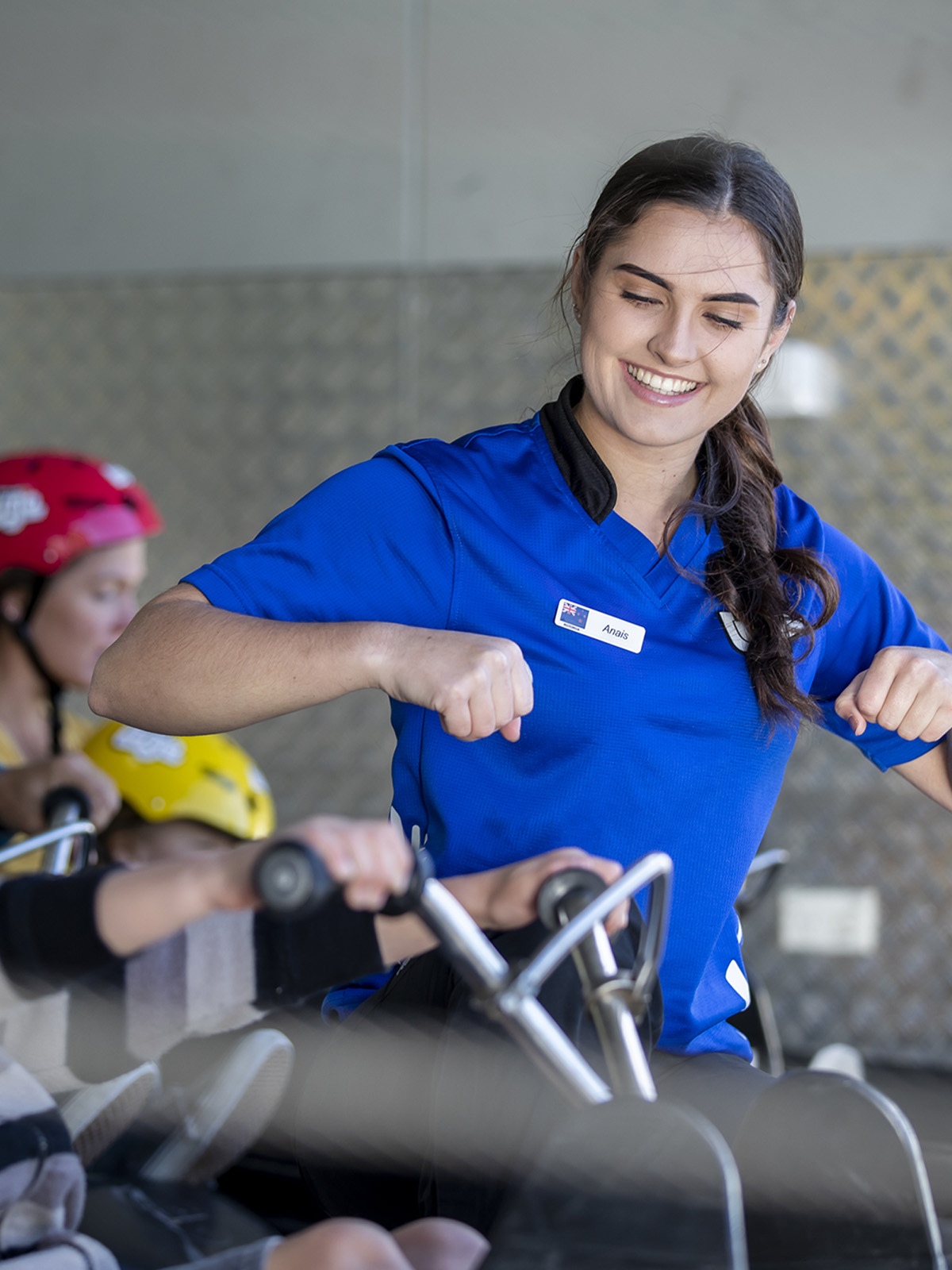Luge staff member explaining to people how to use the luge kart